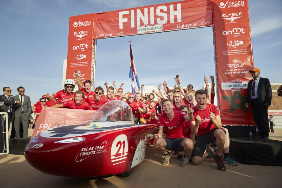 Solar Team Twente staat juigend om de zonne-auto,bij de finisch van de Solar Challenge Morocco de race die ze gewonnen hebben.